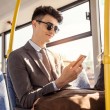 Hombre usando smartphone en autobús urbano